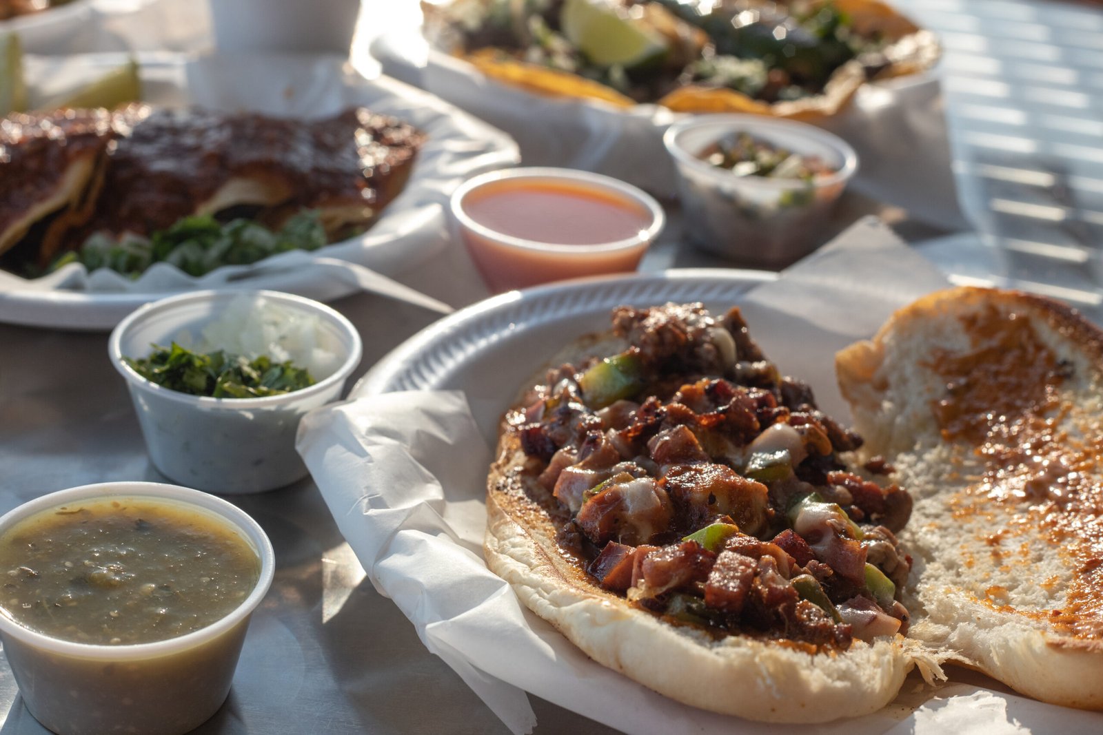 A closeup of Mexican tasty  torta al pastor in a plastic plate and sauces on the side